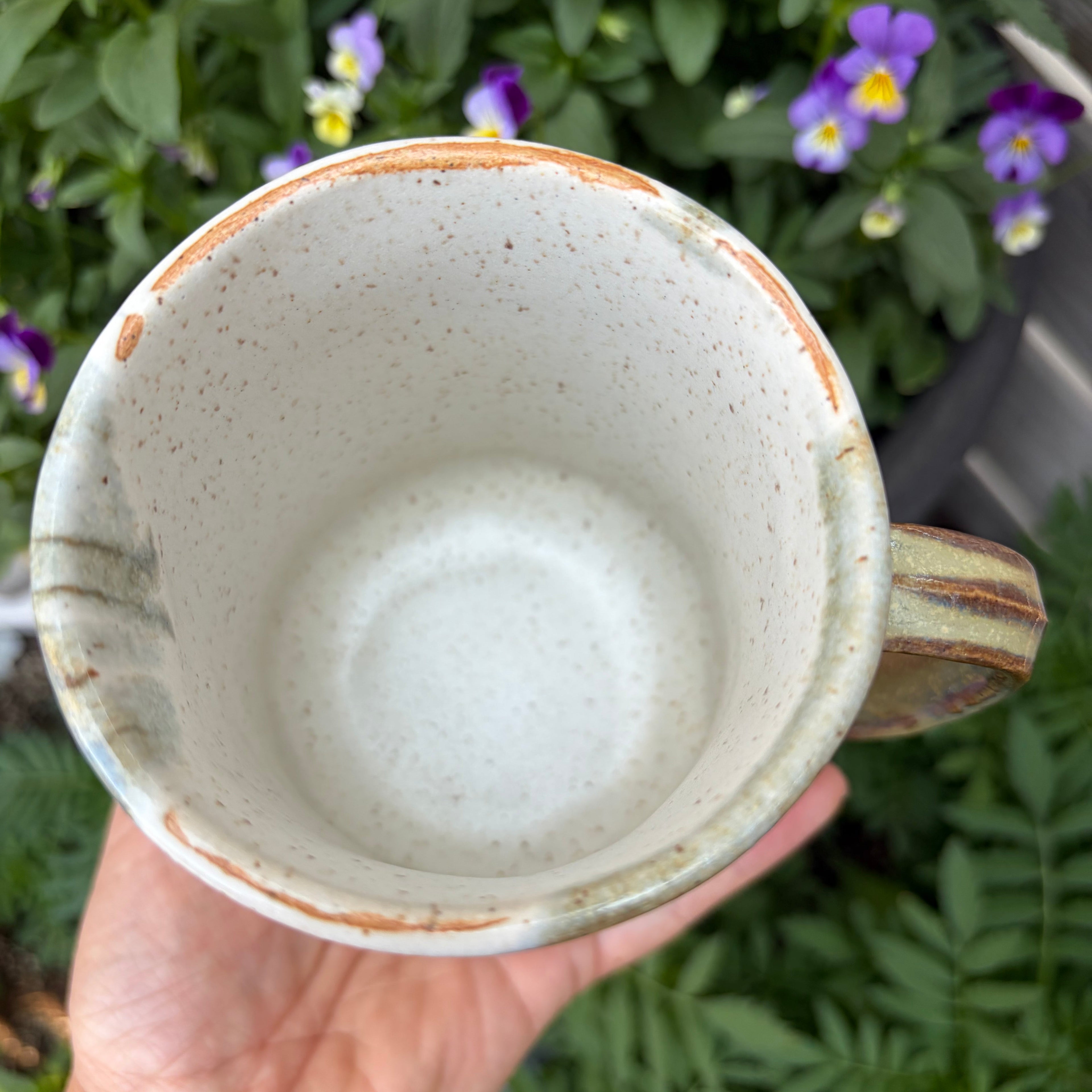 Speckled brown and white interior of a handmade ceramic mug.